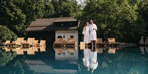 Ein Swimmingpool mit Liegestühlen und einem Gebäude im Hintergrund.