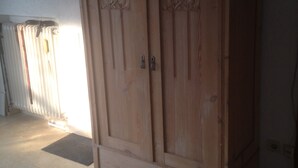 Un'armadio in legno con due ante e un piccolo gradino alla base.