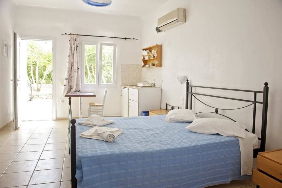 Ein Schlafzimmer mit einem Bett, einem Schreibtisch und einer Küchenzeile.
