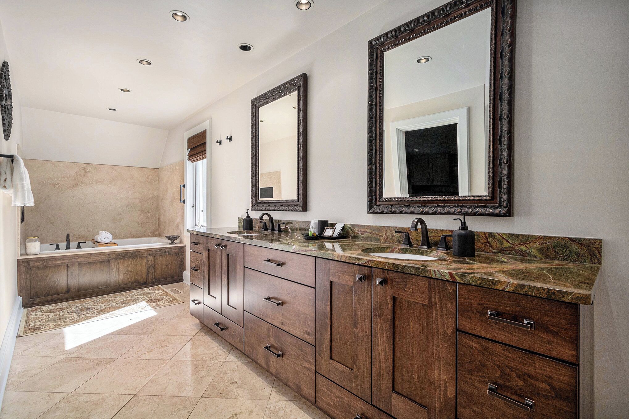 A modern bathroom with a large vanity, double sinks, and a bathtub.