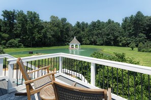 Une terrasse avec un belvédère en arrière-plan, entourée d’une pelouse bien entretenue et d’arbres.