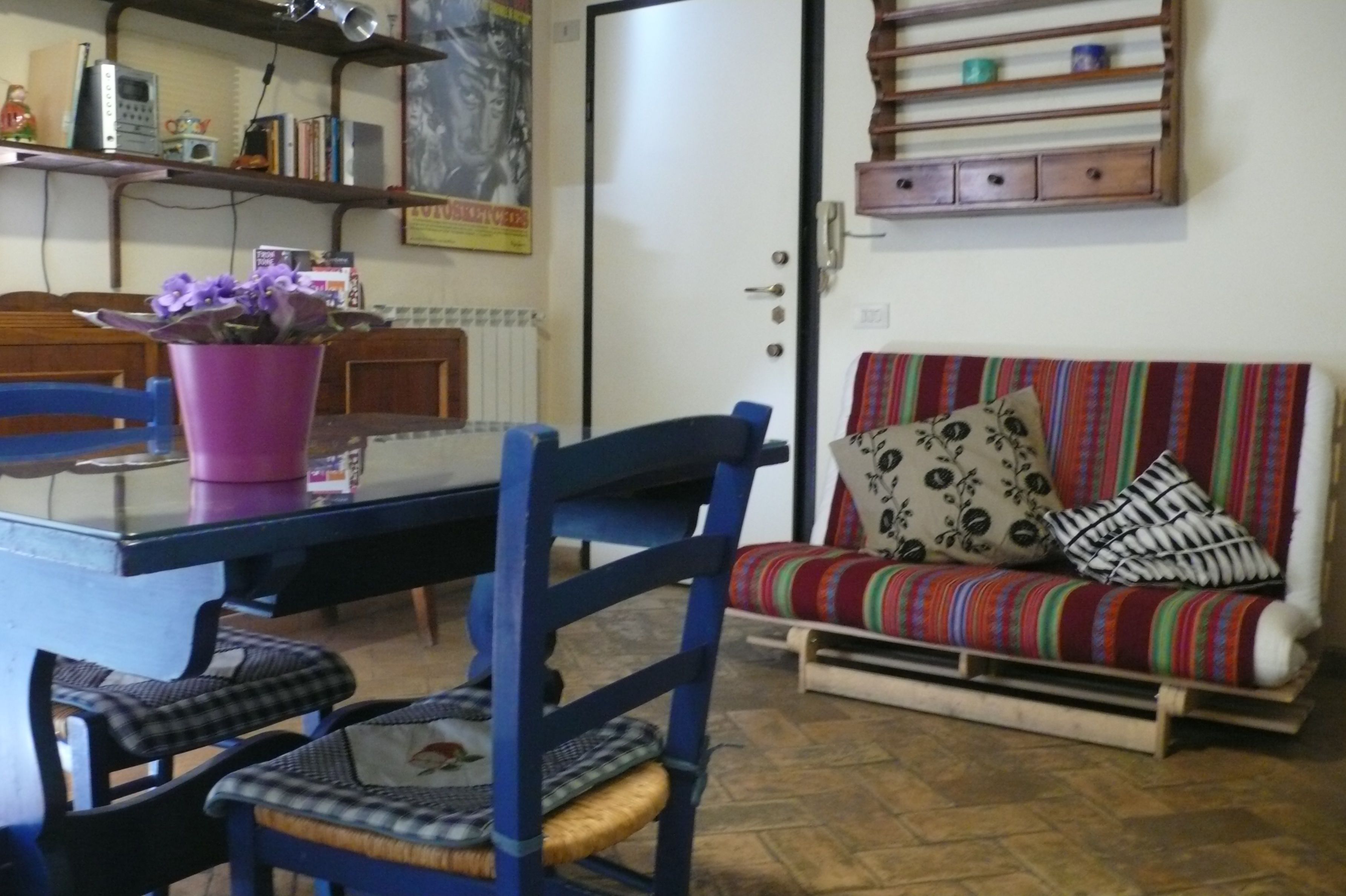 Een gezellige zithoek met een bank, stoelen, een eettafel en een potplant.