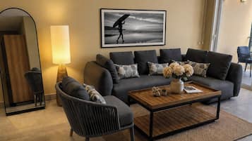 Deluxe kamer, uitzicht op oceaan | Woonruimte | Een 65-inch flatscreentelevisie met kabelzenders en een televisie