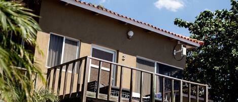 A two-story building with a balcony, a satellite dish, and a door.