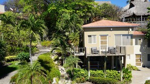 A resort with a pool, a thatched-roof building, and lush greenery. - Casa de Mar Hotel And Villas (Tamanique)