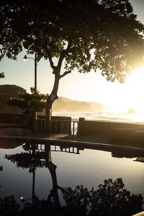 A tree-lined waterfront with a calm body of water reflecting the surroundings.