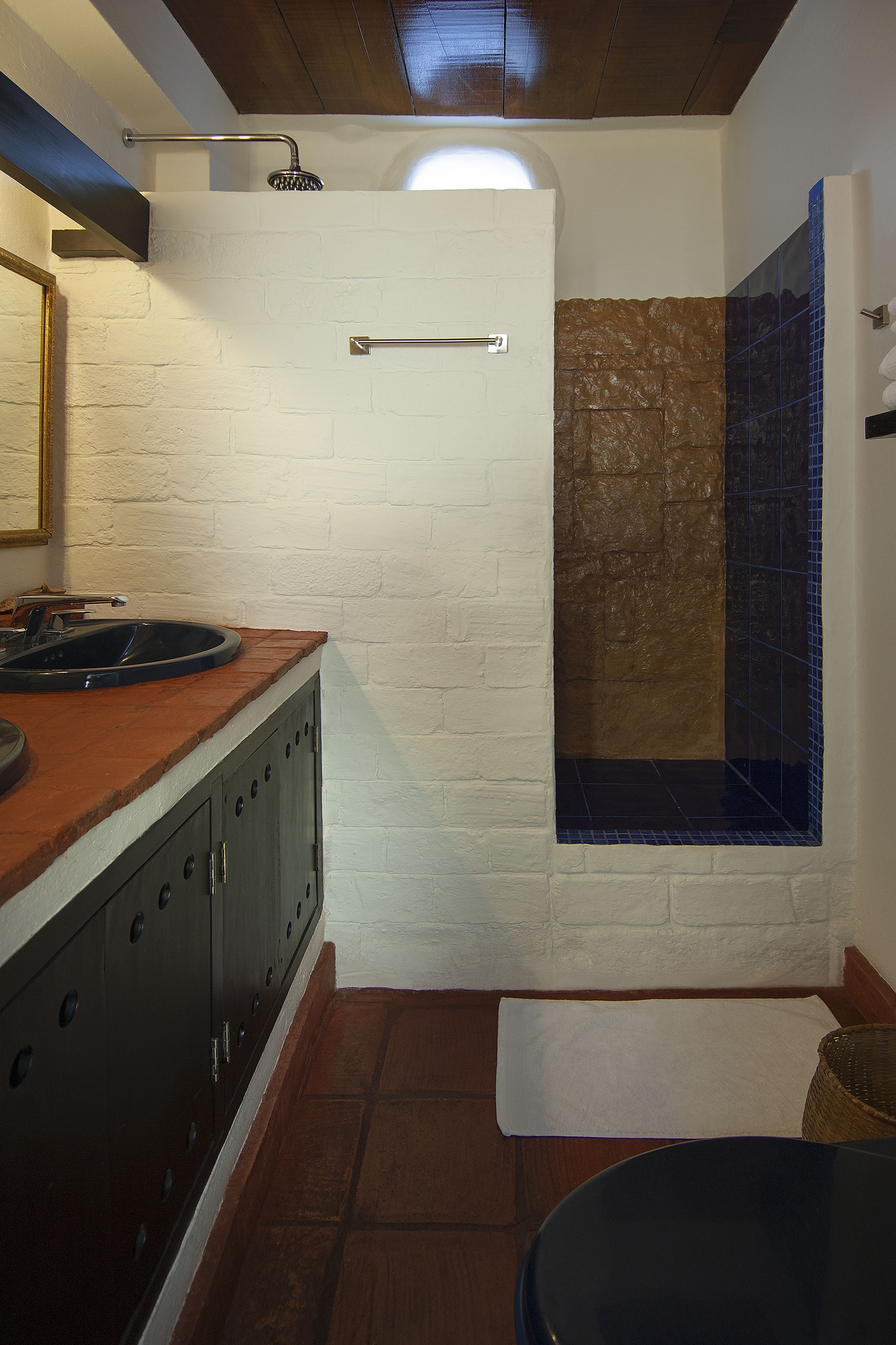 Una cocina con encimera de madera, un lavamanos, armarios y una ventana con vistas a una montaña.