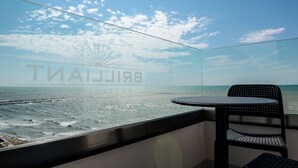 A balcony with a view of the sea, a chair, and a table. - Brilliant Hotel & Spa (Golem)
