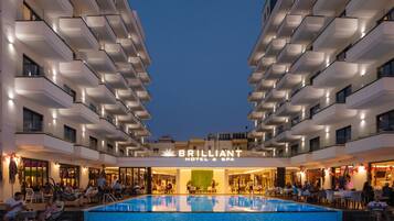 Un hôtel doté d’une grande piscine extérieure, de nombreux balcons et d’une enseigne indiquant « BRILLIANT HOTEL & SPA ».