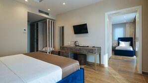 A hotel room with a bed, a desk, a television, and a bathroom visible through an open door. - Brilliant Hotel & Spa (Golem)