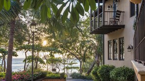 A coastal building with a balcony overlooking the sea, surrounded by lush greenery and a paved pathway. - Santarena Hotel at Las Catalinas (Tempate)