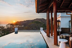 Una piscina al aire libre, sillones reclinables de piscina