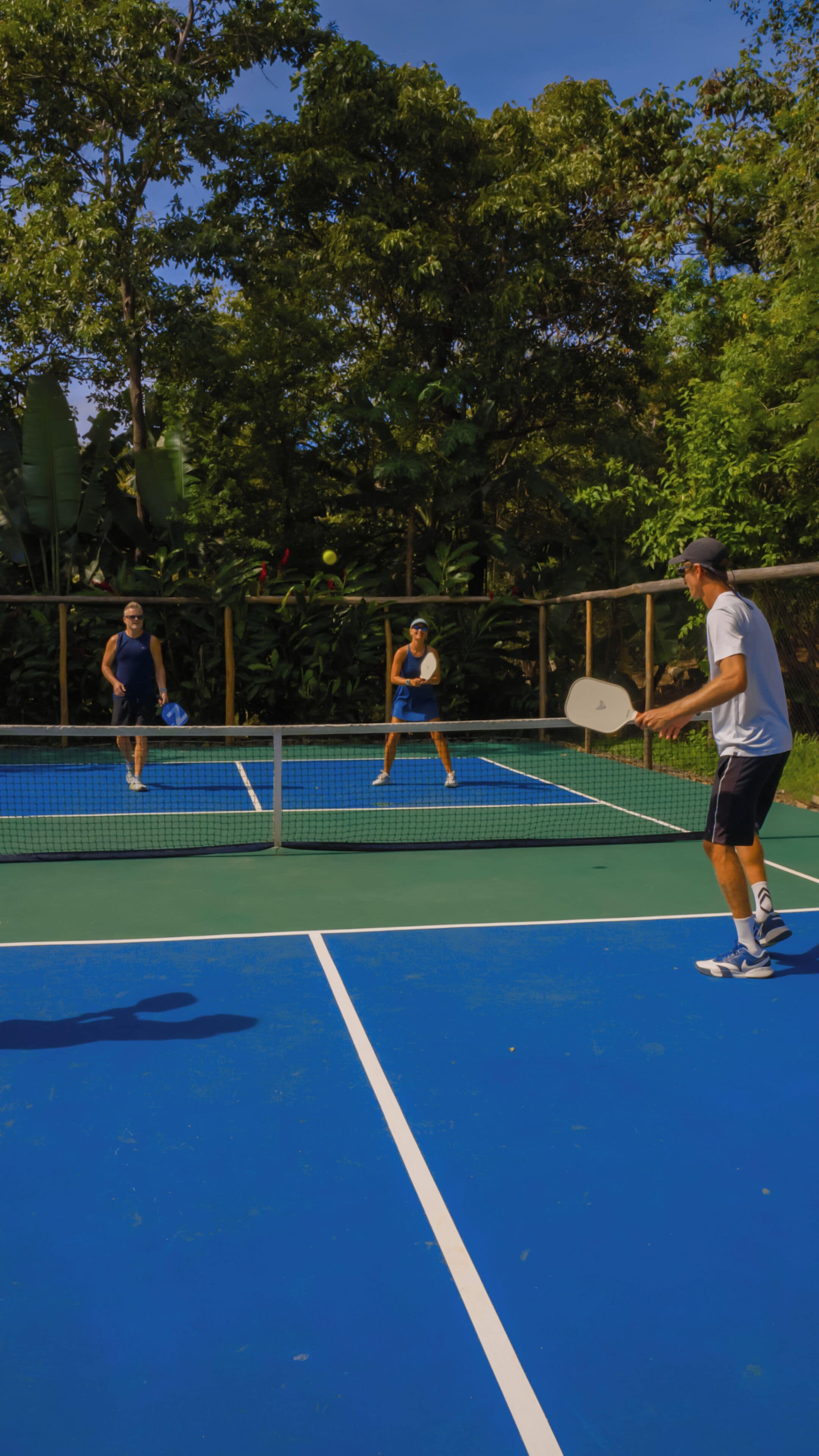 A tennis court with players and a net.