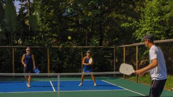 Una cancha de tenis con jugadores y una red.