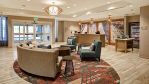 A lobby with a reception desk, seating area, and a view of the outdoors. - Homewood Suites by Hilton Salt Lake City Airport (Salt Lake City)