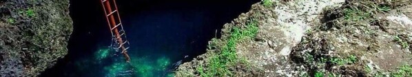 Un estrecho pasaje con una estructura metálica, rodeado de terreno rocoso.