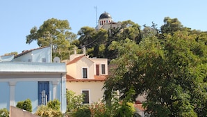 A building with a dome and a bell tower, surrounded by trees and other buildings. - The ideal house at the foot of Acropolis. (Athina)