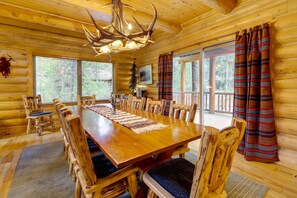 Enjoy meals in this cozy dining area with a large wooden table and comfortable seating for all.