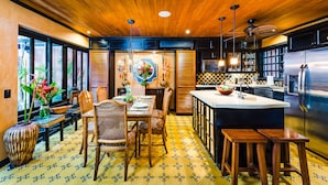 A modern kitchen with wooden ceiling, black cabinets, and a large stainless steel refrigerator. -  Villa Oasis: A luxury villa just steps to beach with private pool, WIFI & A/C  (Tamarindo)