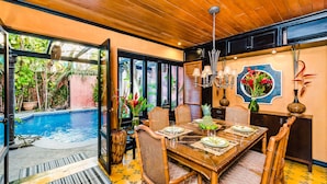 A dining area with a pool view, wooden ceiling, and tropical decor. -  Villa Oasis: A luxury villa just steps to beach with private pool, WIFI & A/C  (Tamarindo)