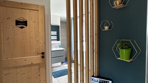 A modern interior with a wooden door, a reception desk, and decorative hexagonal wall mounts. - La Villa d'Hélène Chambres d’hôtes et Appartements-Cluses (Cluses)