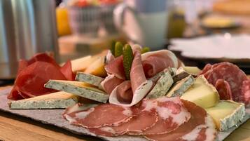 A charcuterie board with various meats and cheeses.