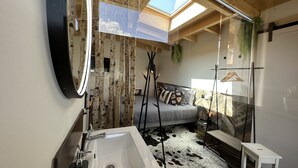 A modern bathroom with a skylight, a large mirror, a sink, and a cowhide rug. - La Villa d'Hélène Chambres d’hôtes et Appartements-Cluses (Cluses)