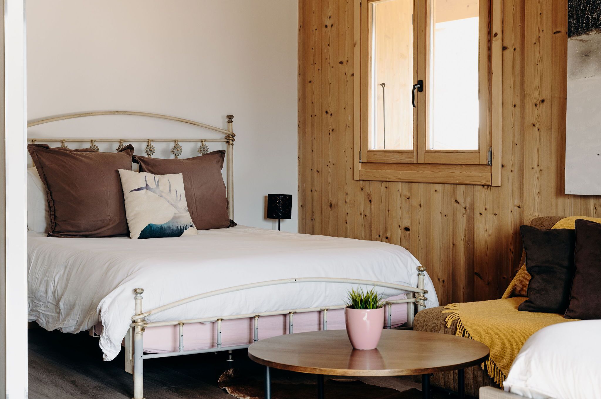 A bedroom with a bed, bedside table, and a window.