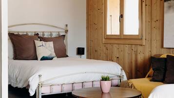 A bedroom with a bed, bedside table, and a window.
