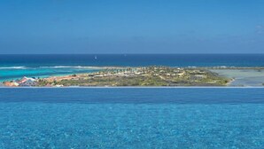 A coastal resort with clear blue waters, a sandy beach, and a small island with buildings. - Luxury Villa Overlooking Orient Bay (SAINT MARTIN)