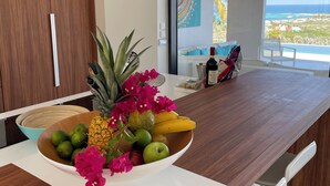 A modern kitchen with a wooden countertop, a bowl of fruit, and a view of the ocean. - Luxury Villa Overlooking Orient Bay (SAINT MARTIN)