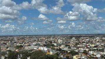 Un paisaje urbano con una zona densa, una iglesia destacada de fachada colorida y un cielo despejado con algunas nubes.