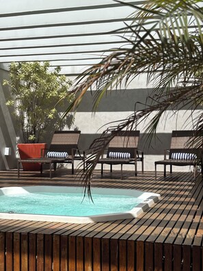 A pool area with lounge chairs and a hot tub. - Promenade Soho Campos dos Goytacazes (Campos)