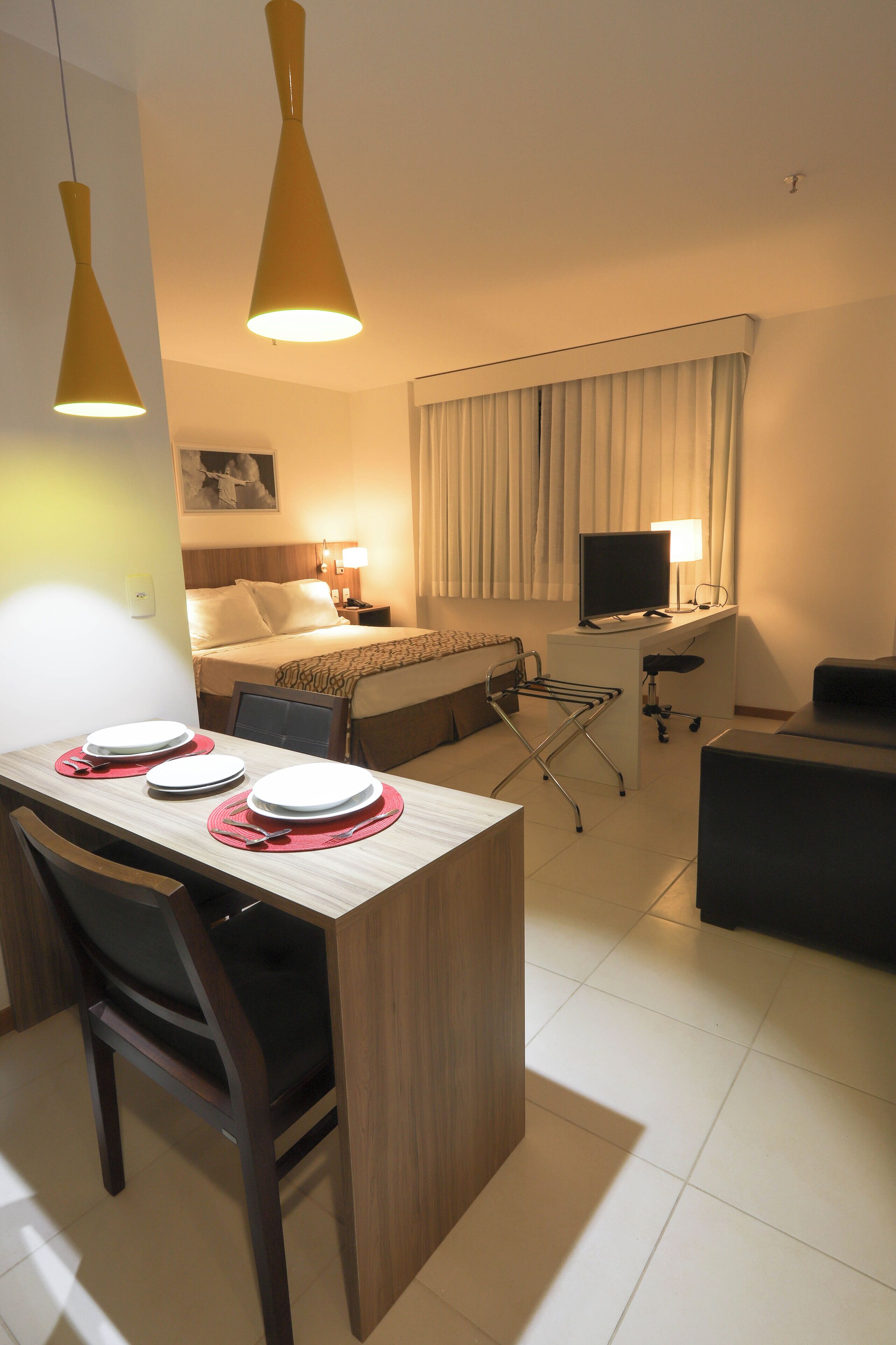 Ein Hotelzimmer mit Bett, Schreibtisch und Essbereich.