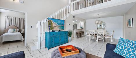 Un vaste salon doté d’un haut plafond, d’un escalier et d’un coin repas.