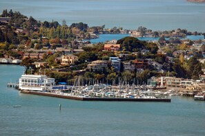 Un puerto deportivo con barcos amarrados, rodeado de edificios residenciales y árboles.