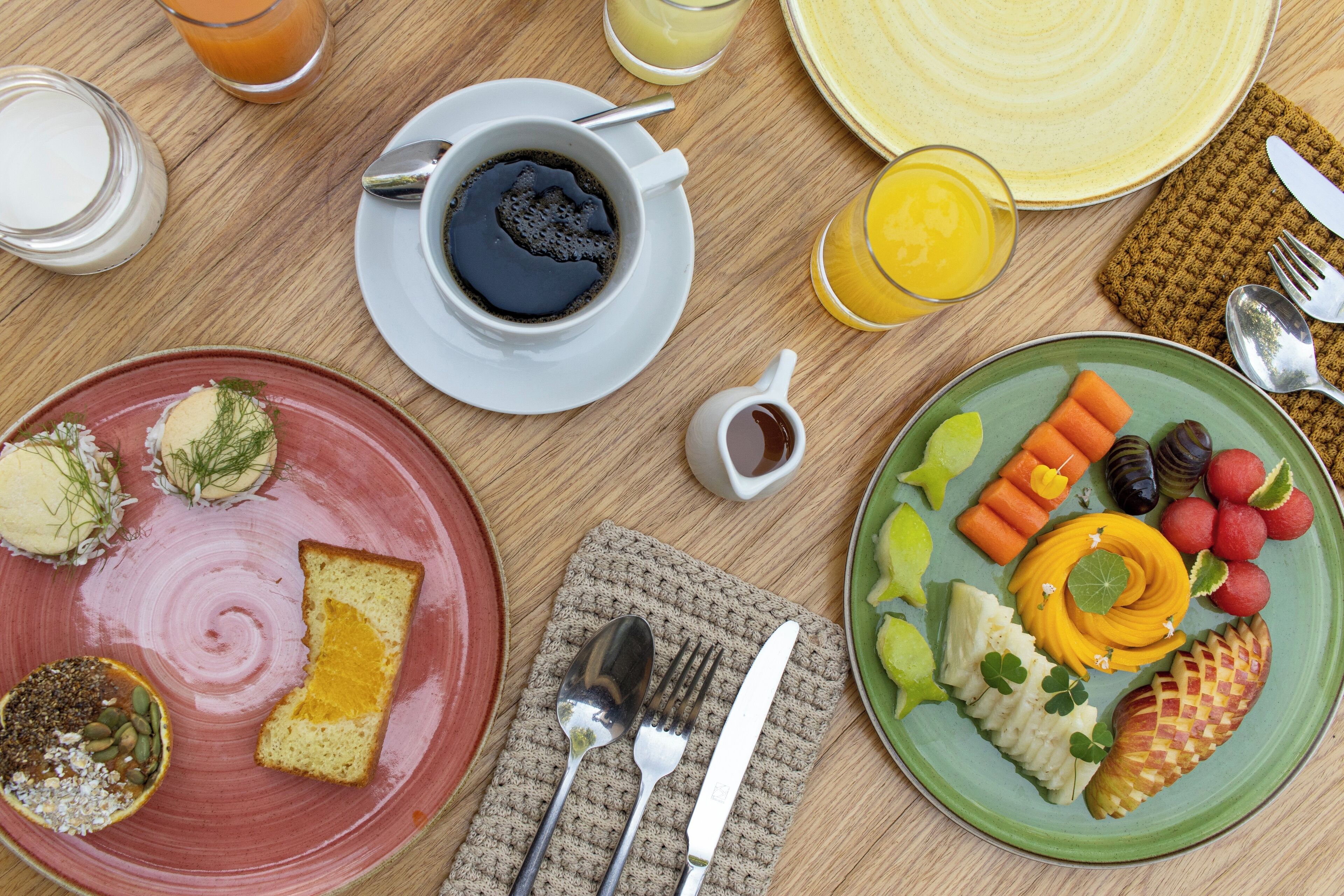 Desayuno con diversos platos, incluyendo tostadas, fruta y una taza de café.