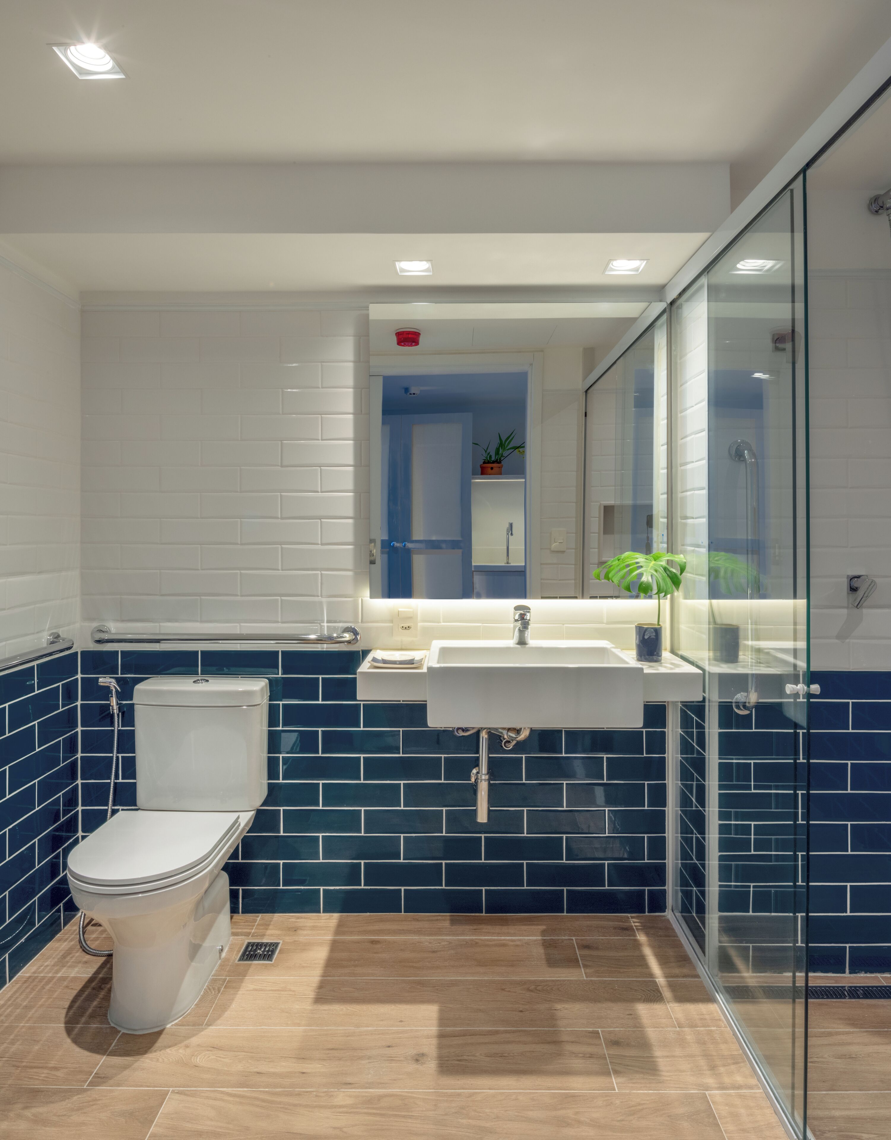 Un baño moderno con inodoro, lavamanos y cabina de ducha de vidrio.