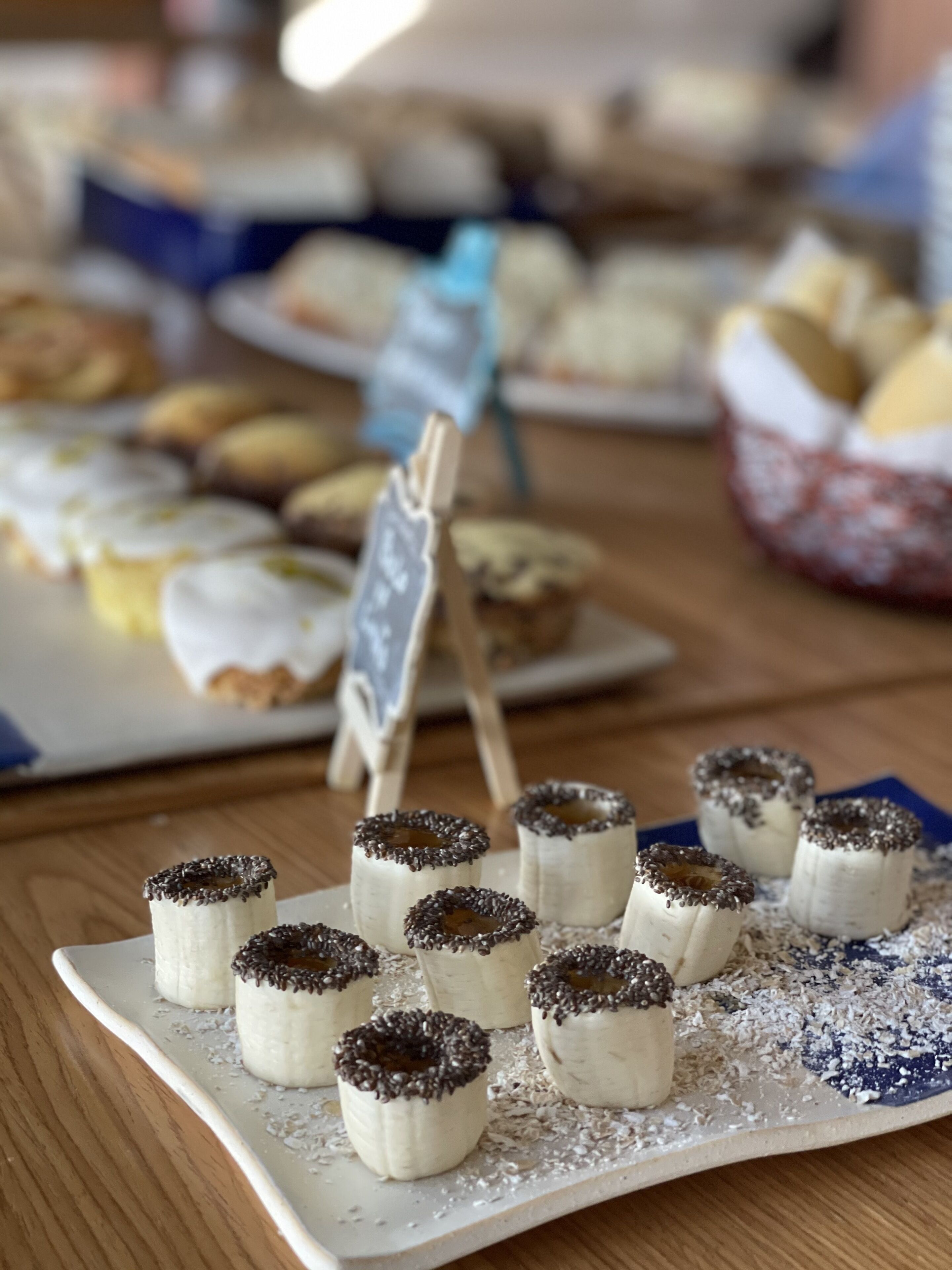 Una bandeja de postres con pasteles pequeños cubiertos de grageas de chocolate.