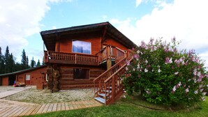 A wooden cabin with a balcony and a staircase leading to an upper level. - Northern Sky Lodge (Fairbanks)