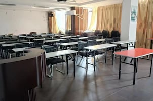 Un salón de conferencias con mesas y sillas dispuestas para reuniones.