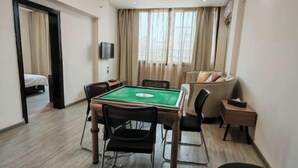 A room with a pool table, a sofa, a TV, and a bed. - Cang Long Hotel (Hezhou)