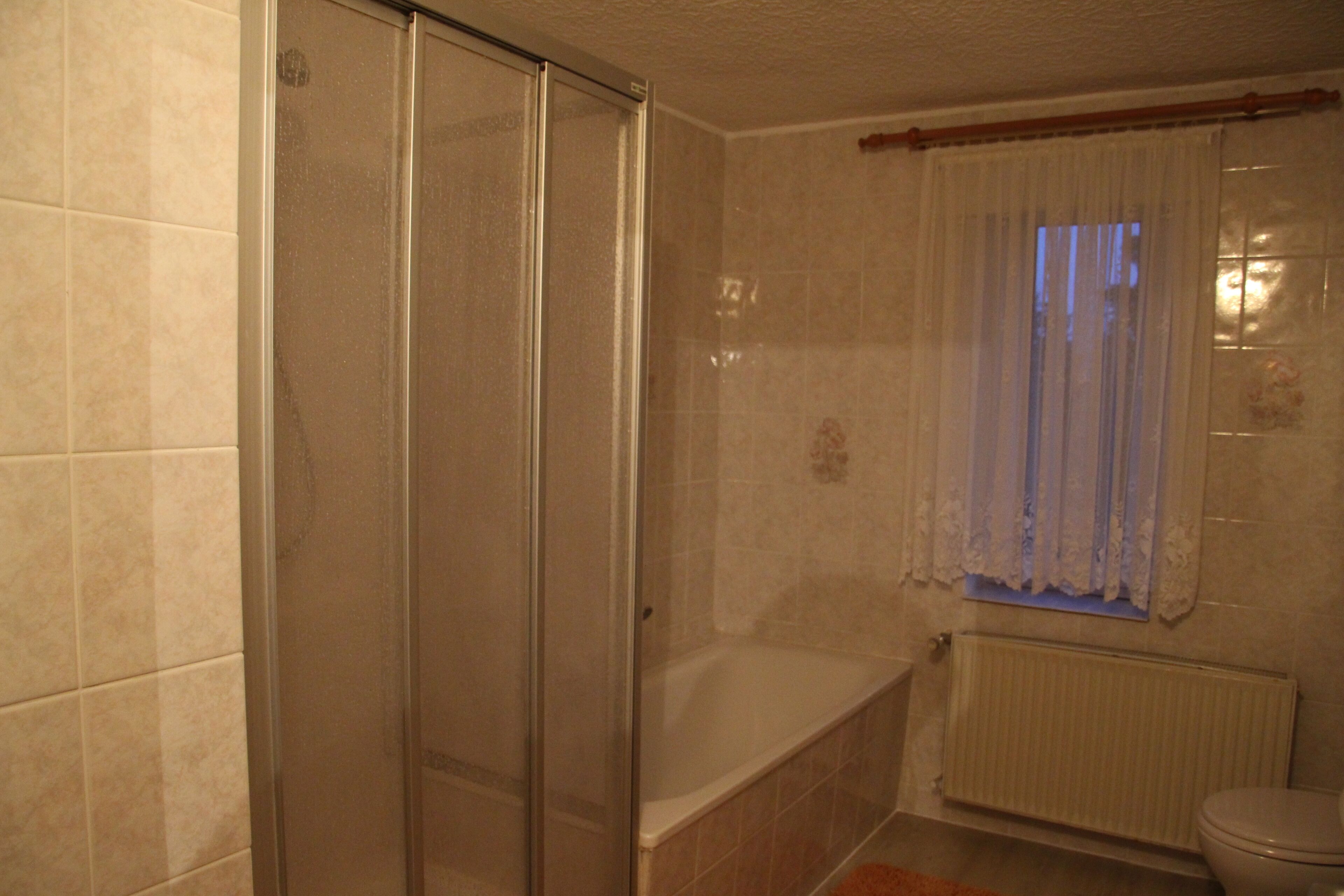 A bathroom with a shower, bathtub, and toilet.