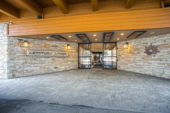 The entrance of Keystone Lodge with stone walls and a sign.