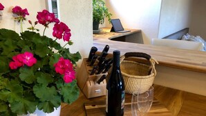 A kitchen counter with a potted plant, a wine bottle, and a knife block.