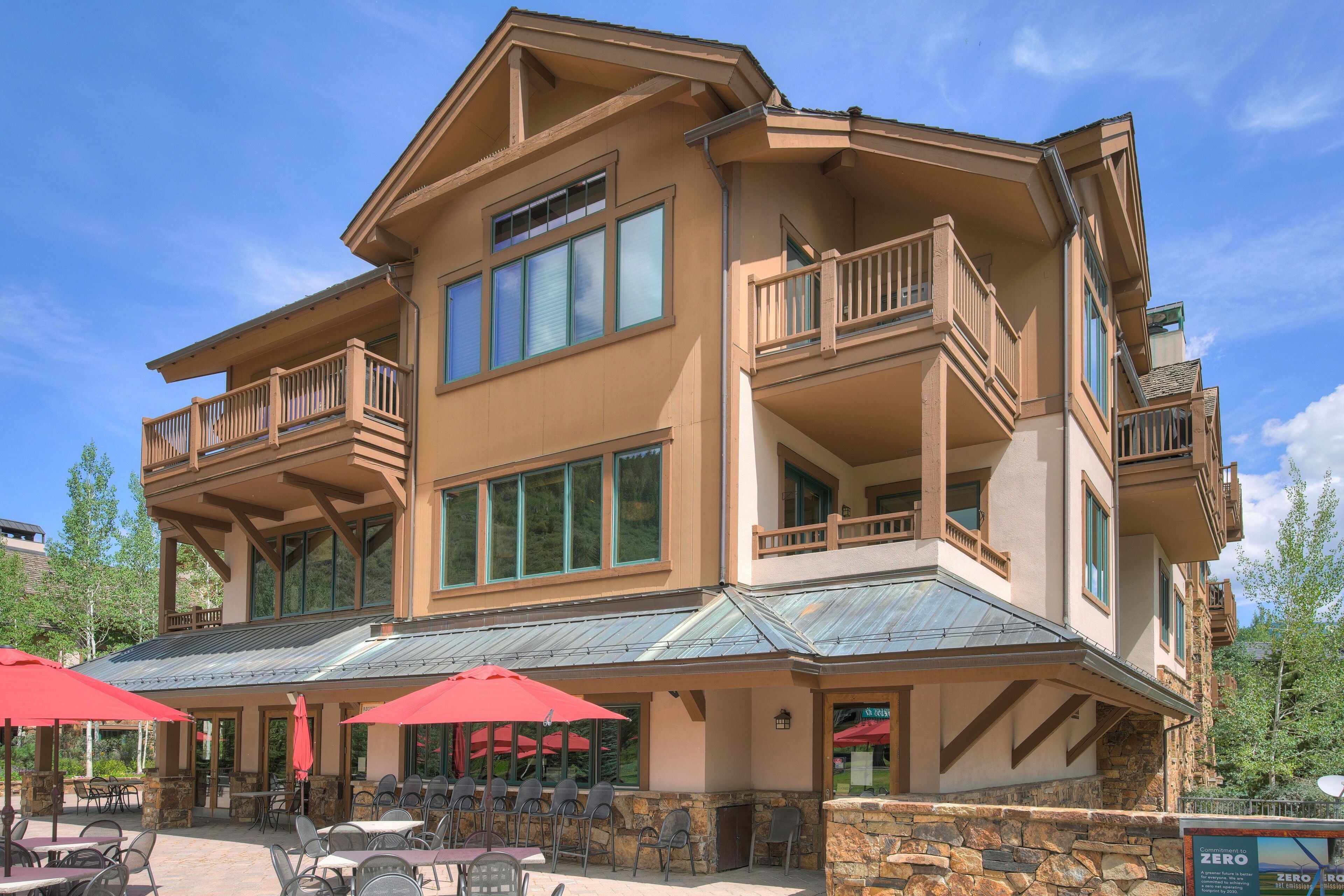 A multi-story building with outdoor seating and a stone facade.