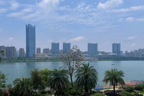 Une vue sur les gratte-ciel d’une ville, avec des bâtiments modernes et une étendue d’eau au premier plan.