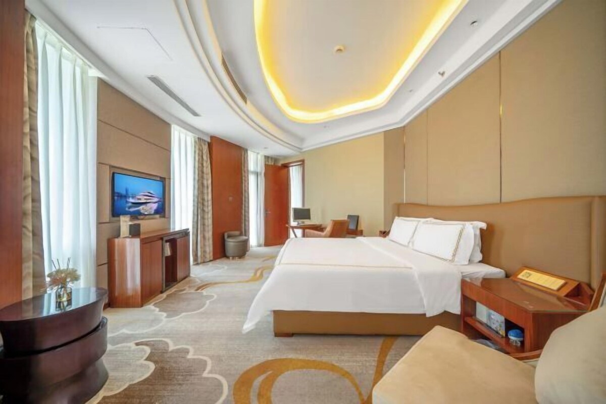 Une chambre d’hôtel dotée d’un grand lit, d’une télévision, d’un bureau et d’un coin salon.