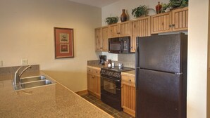 A kitchen with granite countertops, stainless steel appliances, wooden cabinets, and a built-in microwave. - Peaceful and Comfortable 3 Bedroom Condo (Breckenridge)