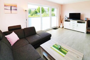 A modern living room with a sofa, a coffee table, a TV, and a cabinet.